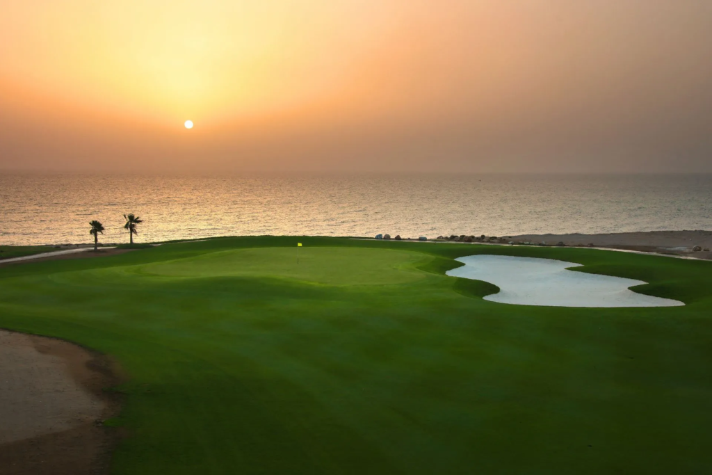 Jebel Sifah seaside golf course by Harradine at sunset