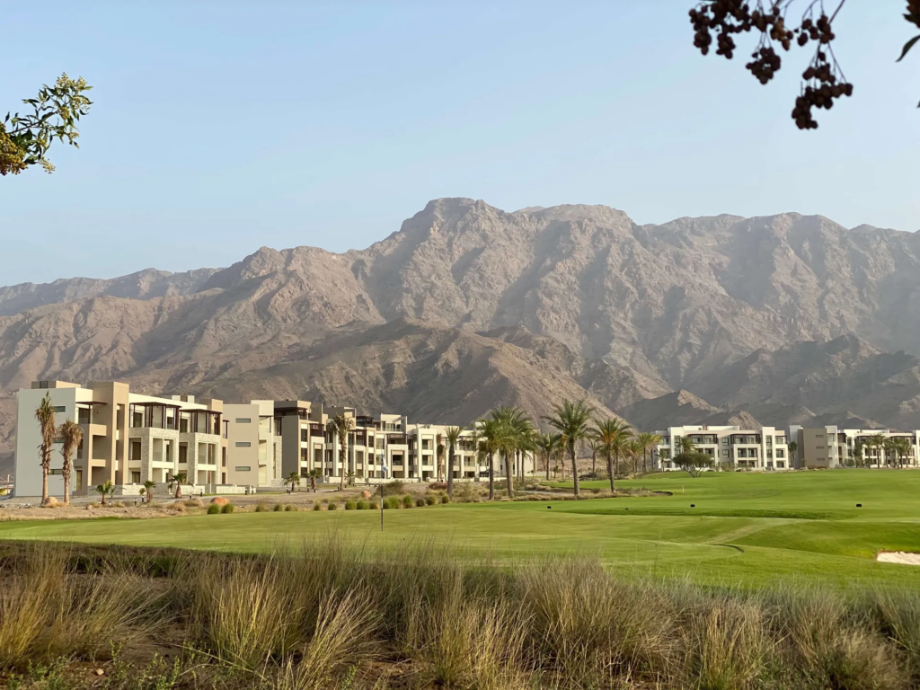 Jebel Sifah Heights homes beside the golf course with the Hajar mountains behind